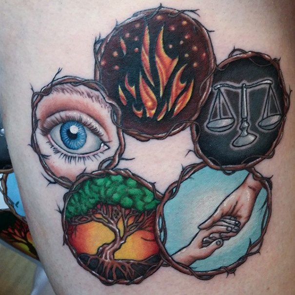 Tattoo featuring an eye, fire, scales, tree, and hands for bookworms.