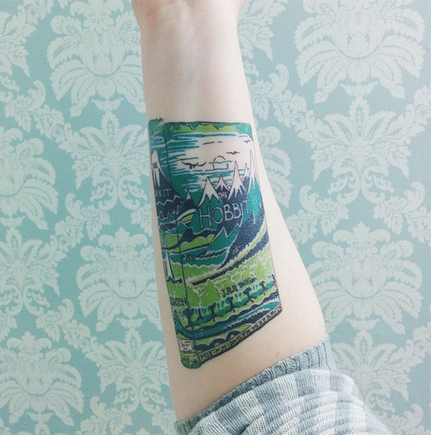 Tattoo of "The Hobbit" book cover on forearm, ideal for bookworms seeking book-inspired ink.