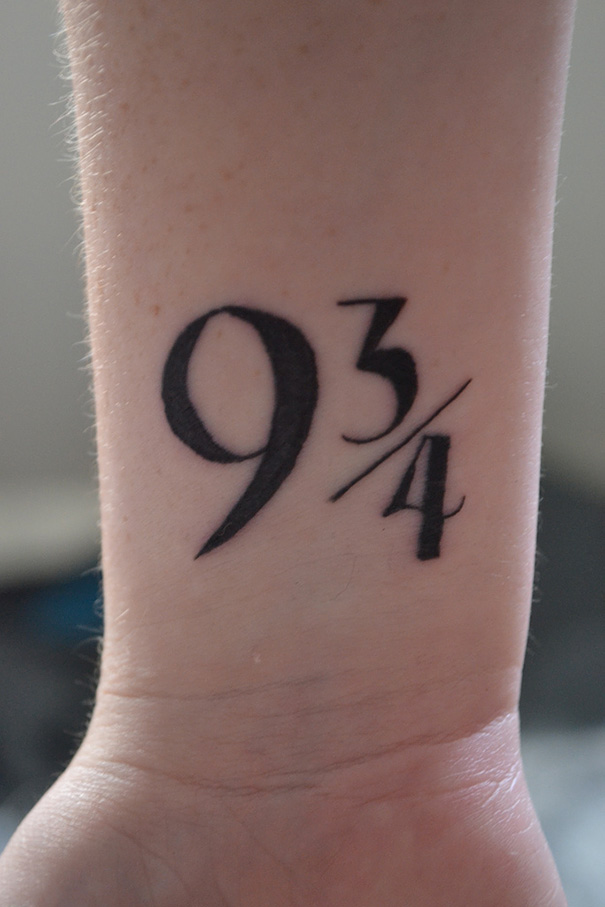 Tattoo of "9 3/4" on a wrist, a book-inspired design for bookworms.