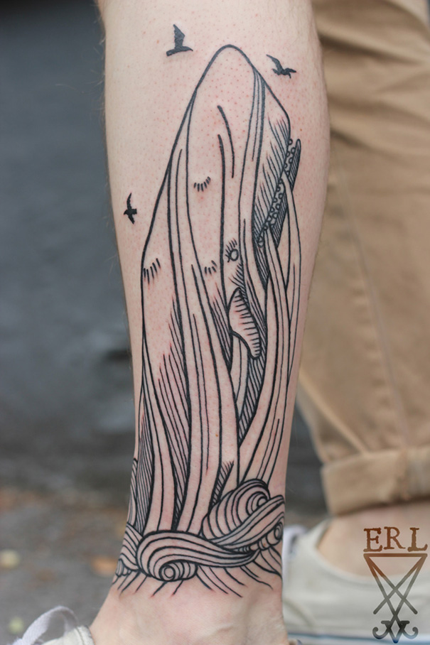 Tattoo of a whale and ocean waves inspired by a book, designed on a person's leg.