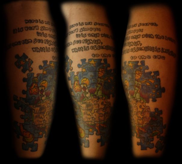 Colorful tattoo featuring book-inspired puzzle pieces and text.