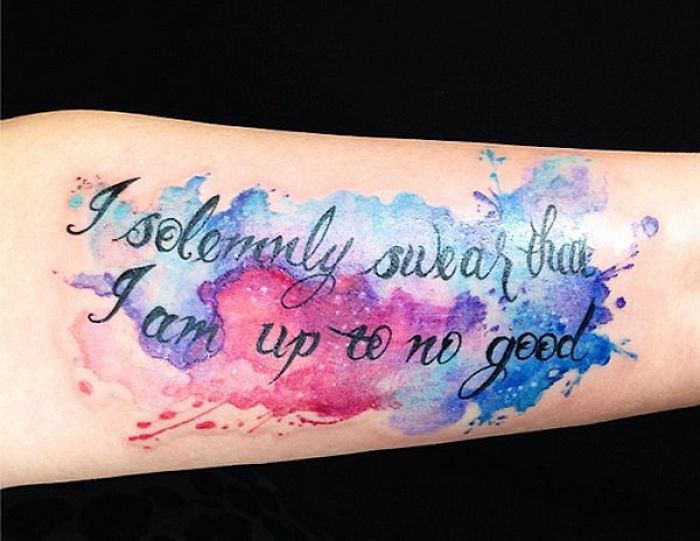 Watercolor Harry Potter tattoo with quote, "I solemnly swear that I am up to no good," on forearm.