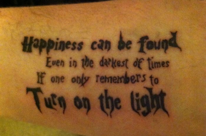 Harry Potter tattoo with quote about finding happiness in dark times in stylized script.