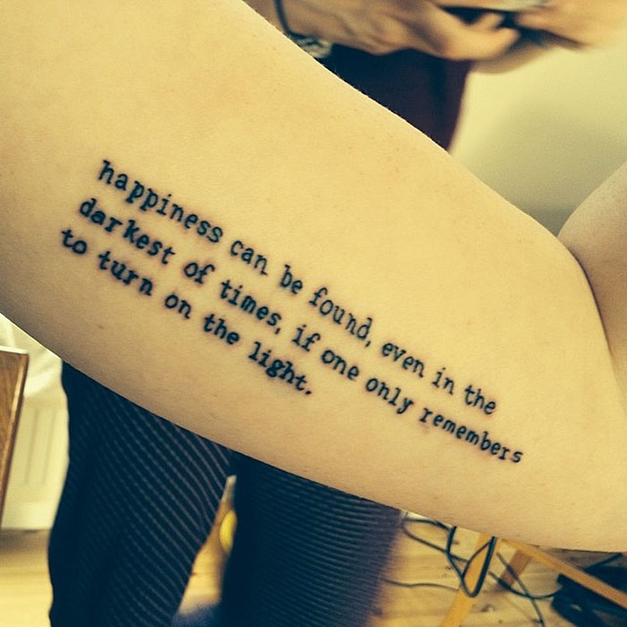 Harry Potter tattoo with inspirational quote on arm in black ink.