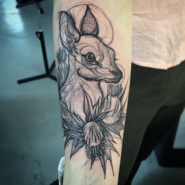 Sketch tattoo resembling a pencil drawing of a deer and flowers on an arm by Nomi Chi.