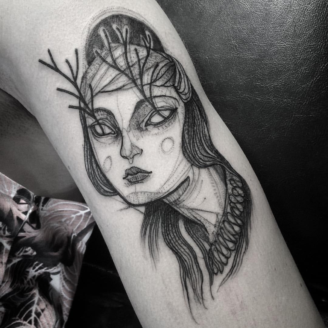 Sketch tattoo resembling a pencil drawing by Nomi Chi, featuring a stylized face with intricate line work.