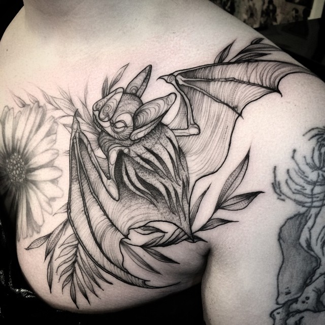 Sketch tattoo resembling a pencil drawing of a bat on a person's shoulder.