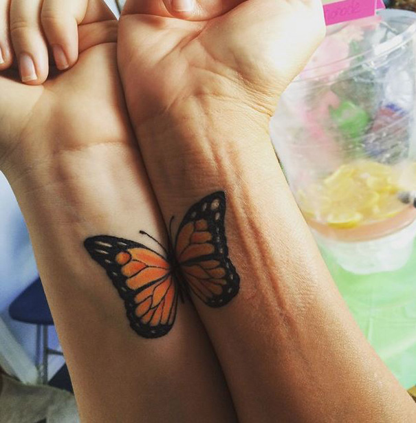 Butterfly tattoos on wrists symbolizing the unbreakable bond between mother and daughter.