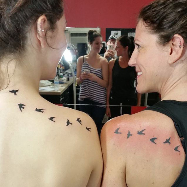Mother-daughter tattoos of flying birds on shoulders symbolize their unbreakable bond.