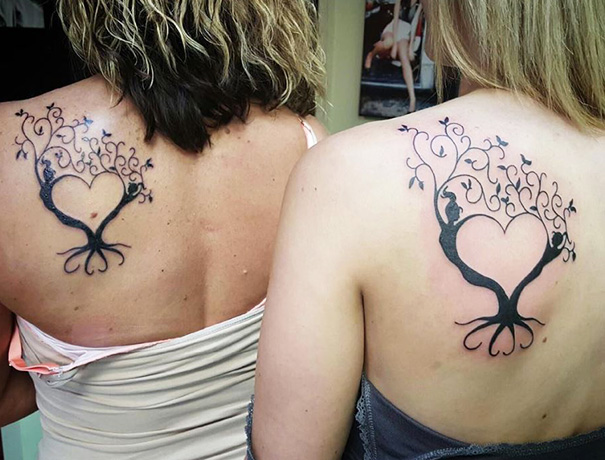 Mother-daughter tattoos featuring intertwined heart-shaped trees on their backs, symbolizing a strong bond.