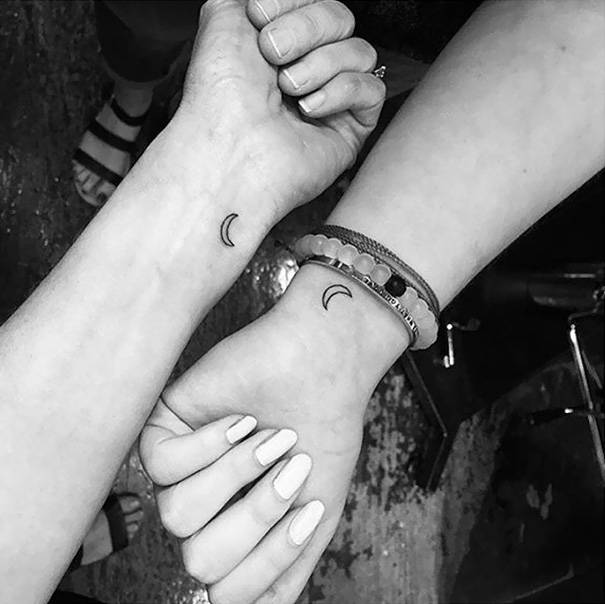 Mother-daughter tattoos of crescent moons on wrists, symbolizing their bond.