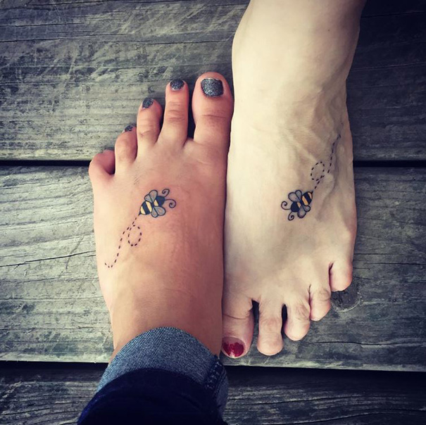 Matching bee tattoos on mother and daughter feet, symbolizing their unbreakable bond.