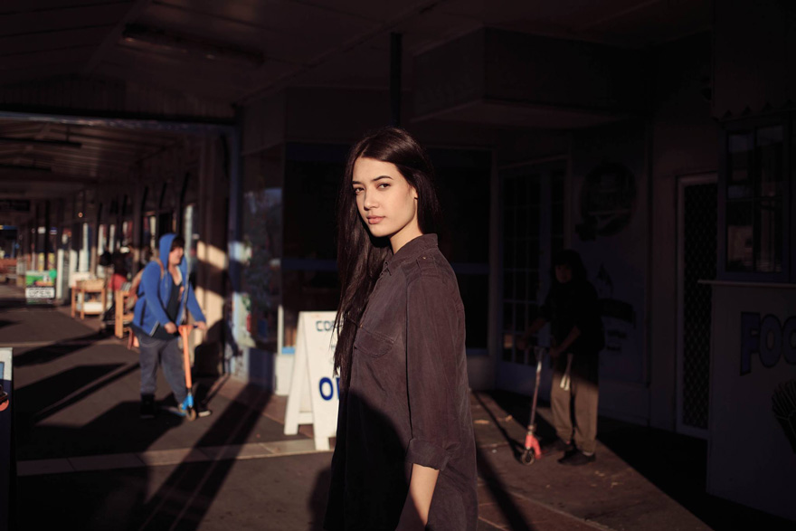 Romanian photographer captures a woman standing in an urban setting, showcasing diverse beauty.