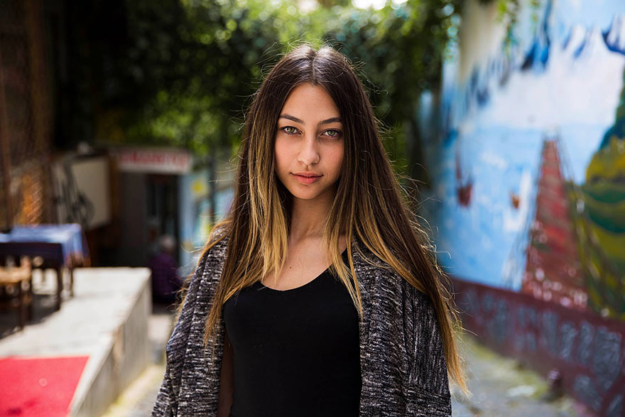 Young woman photographed by Romanian photographer, showcasing diverse beauty in an outdoor urban setting.