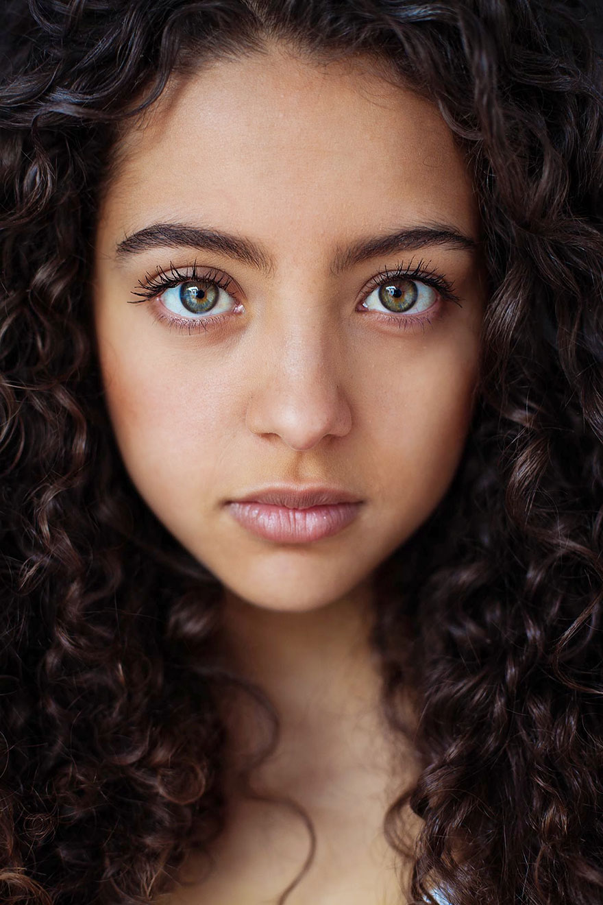 Portrait of a woman with curly hair, captured by Romanian photographer, showcasing global beauty.