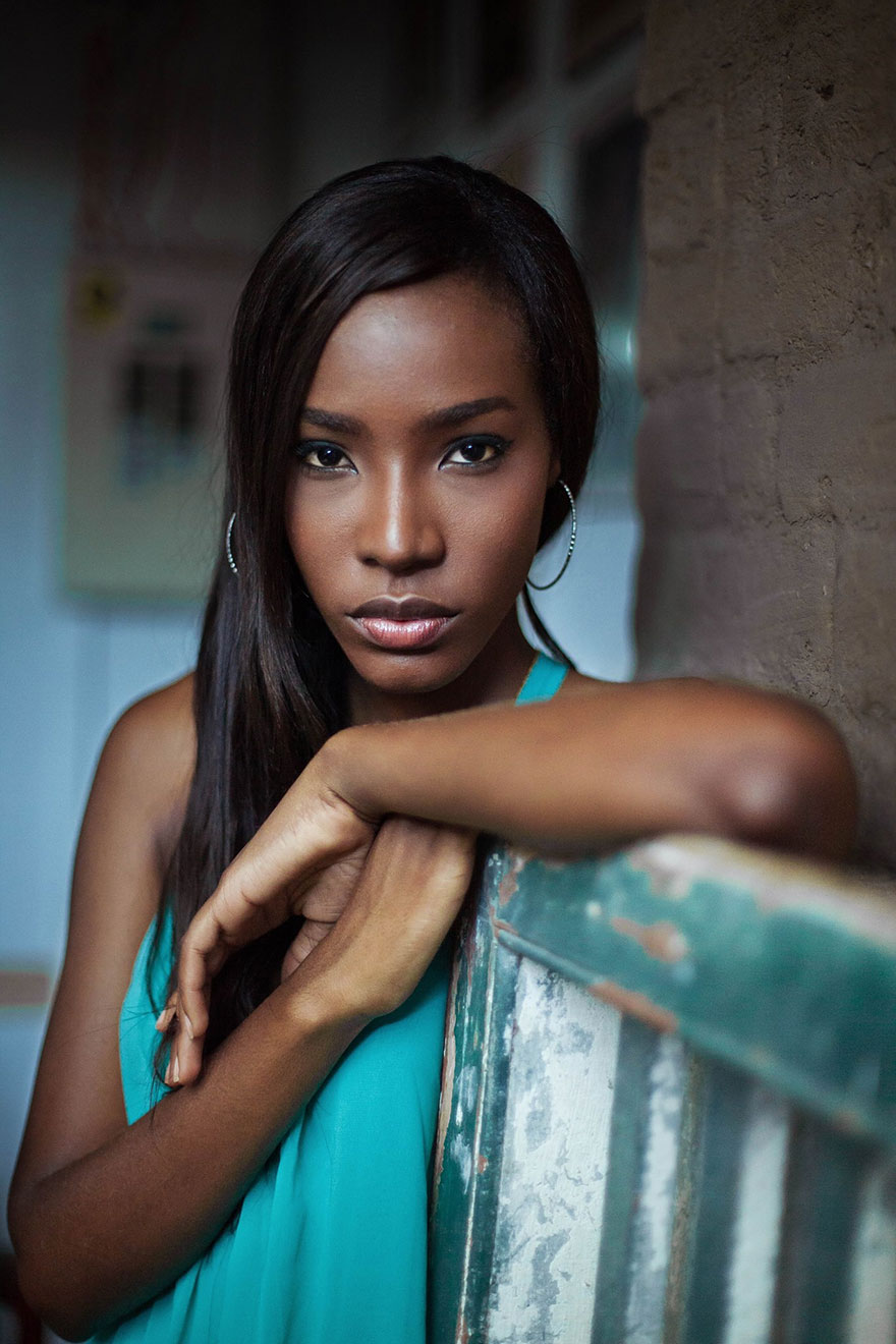 Woman in a teal dress poses confidently, showcasing Romanian photographer's vision of global beauty.
