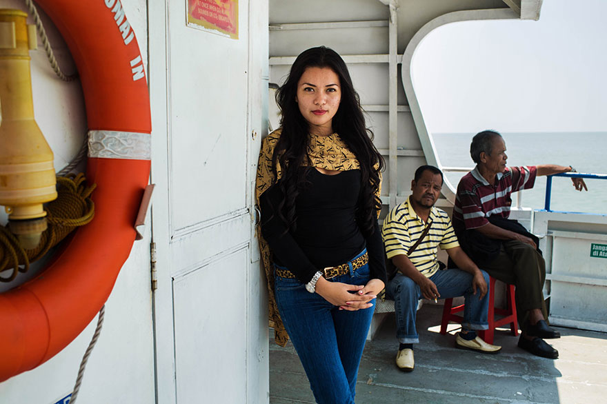 Woman on a boat photographed by Romanian photographer, showcasing global beauty.