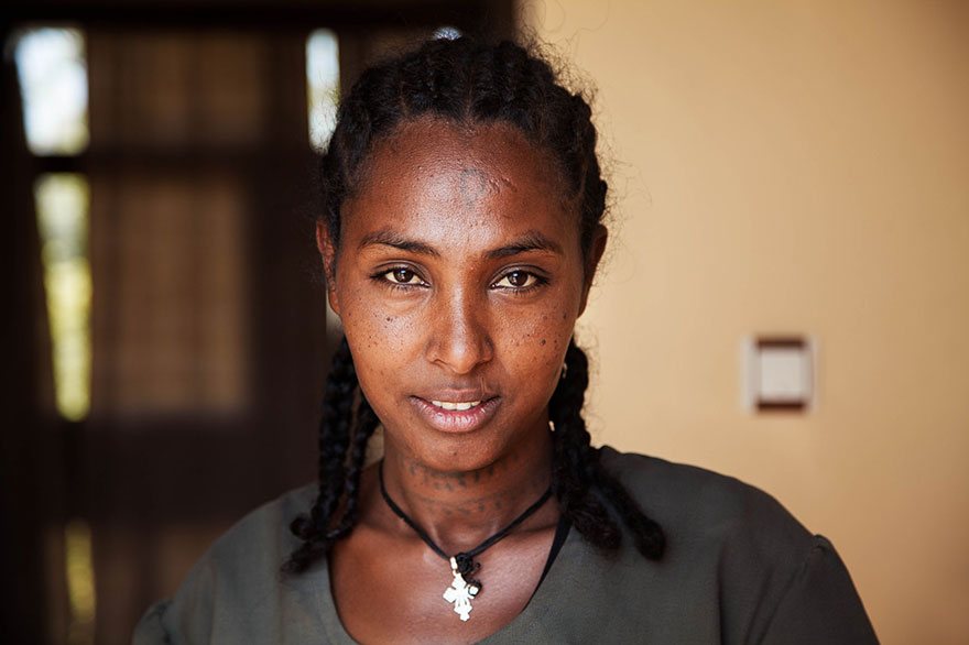 Portrait by Romanian photographer showing diverse beauty, featuring a woman with braids in a natural setting.