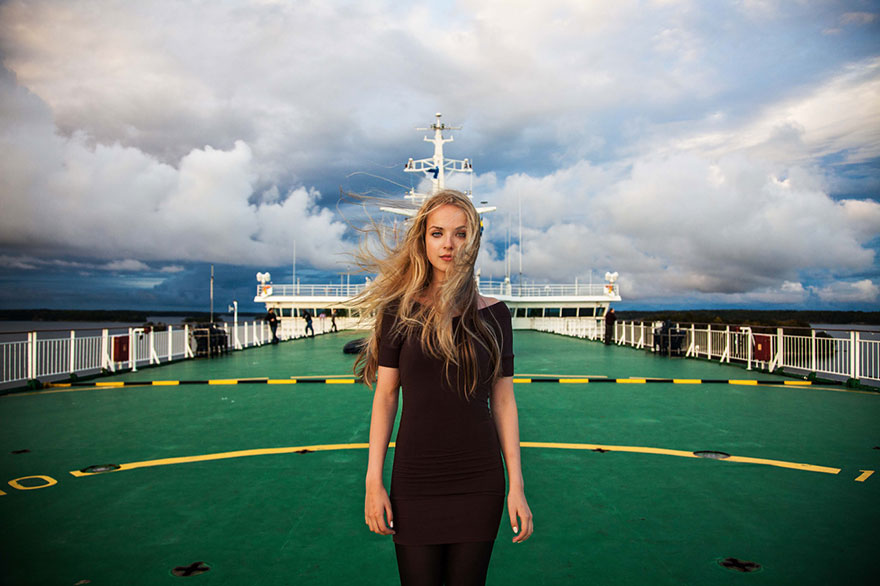Woman on a ship deck, with a dramatic cloudy sky, representing worldwide beauty, shot by Romanian photographer.