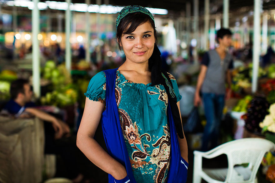Woman from 121 countries project by Romanian photographer, featuring diverse beauty in a vibrant market setting.