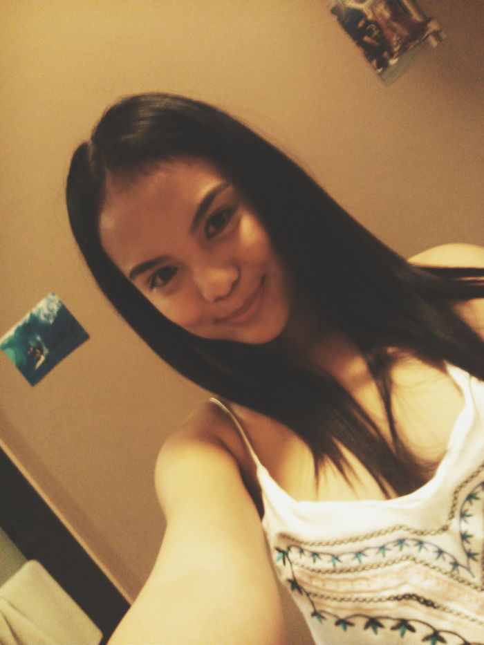 Young woman with long dark hair taking a selfie, illustrating kids as copy-paste versions of their parents.