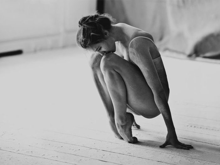 Ballet dancer in a pensive pose, highlighting the dedication and effort behind ballet.