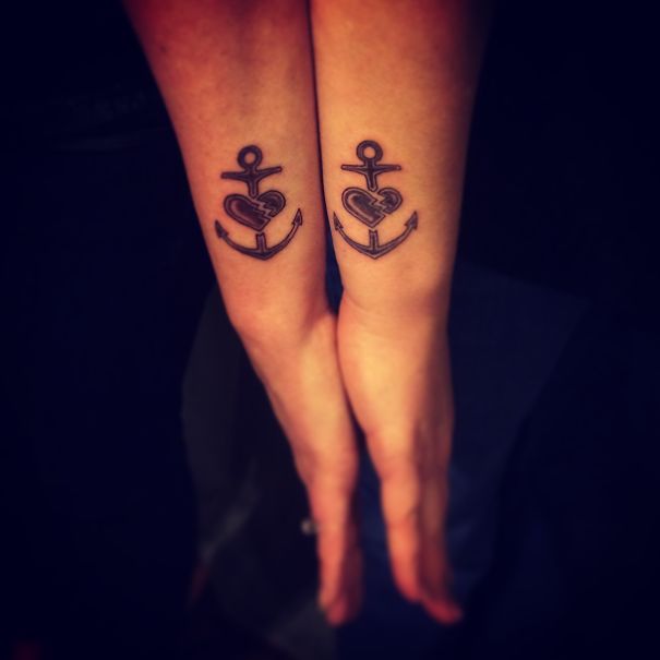 Matching anchor and heart tattoos on forearms, symbolizing a sister bond.