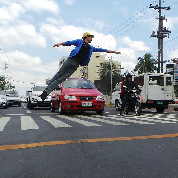 Ballet dancer in mid-air, performing a leap across a crosswalk, celebrating Ballet Day amidst urban traffic.