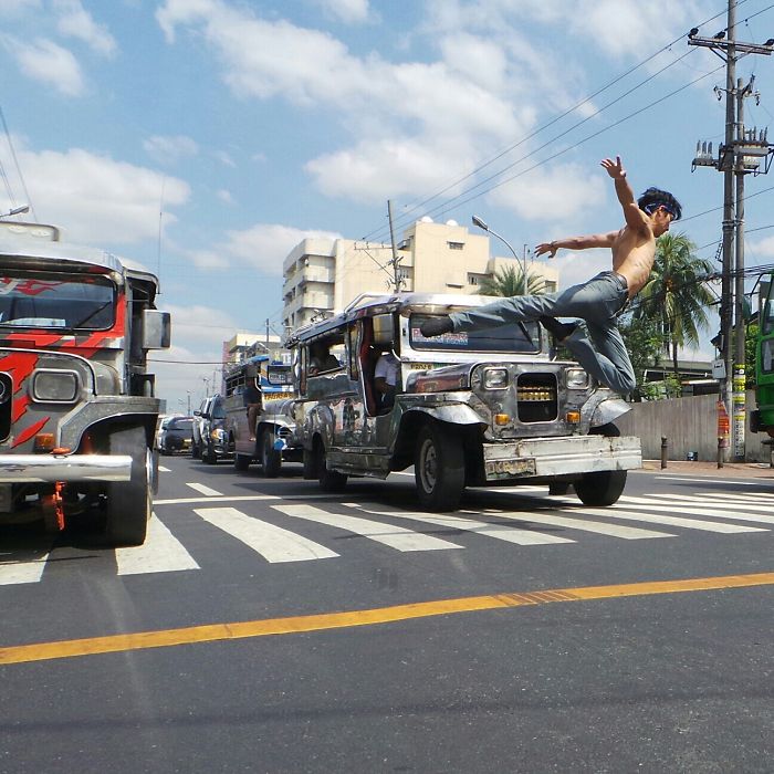 Dancer leaps gracefully over a jeepney in a vibrant urban setting, blending ballet with street art.