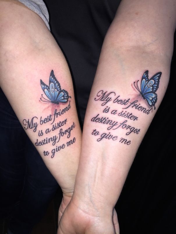 Matching sister tattoos with blue butterfly and friendship quote on forearms.