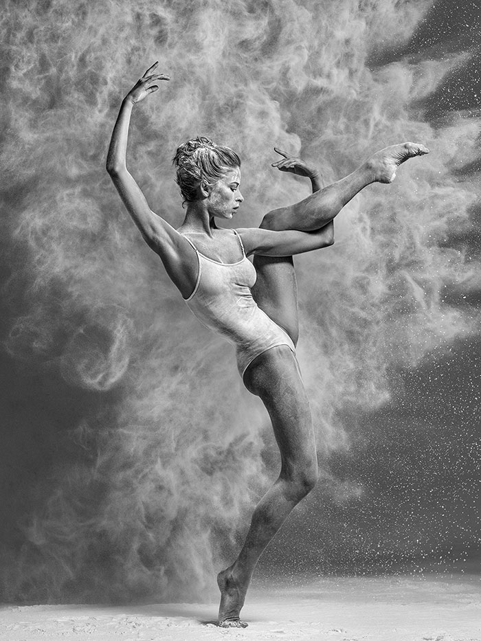Ballet dancer striking a pose, silhouetted against a backdrop of swirling powder, showcasing the artistry of ballet.