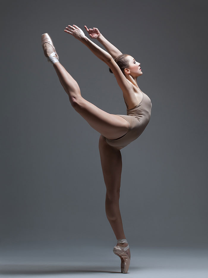 Ballet dancer in a graceful arabesque pose, showcasing the elegance and strength of ballet performance.