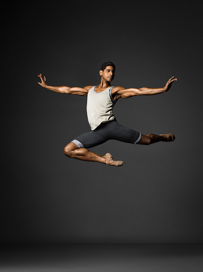 Ballet dancer performing a grand jeté mid-air, showcasing grace and athleticism.