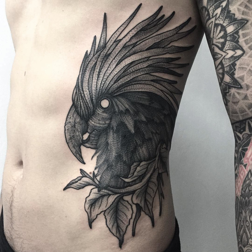 Dark and eerie creature tattoo of a bird on a person's side, showcasing detailed artistry by a Russian artist.
