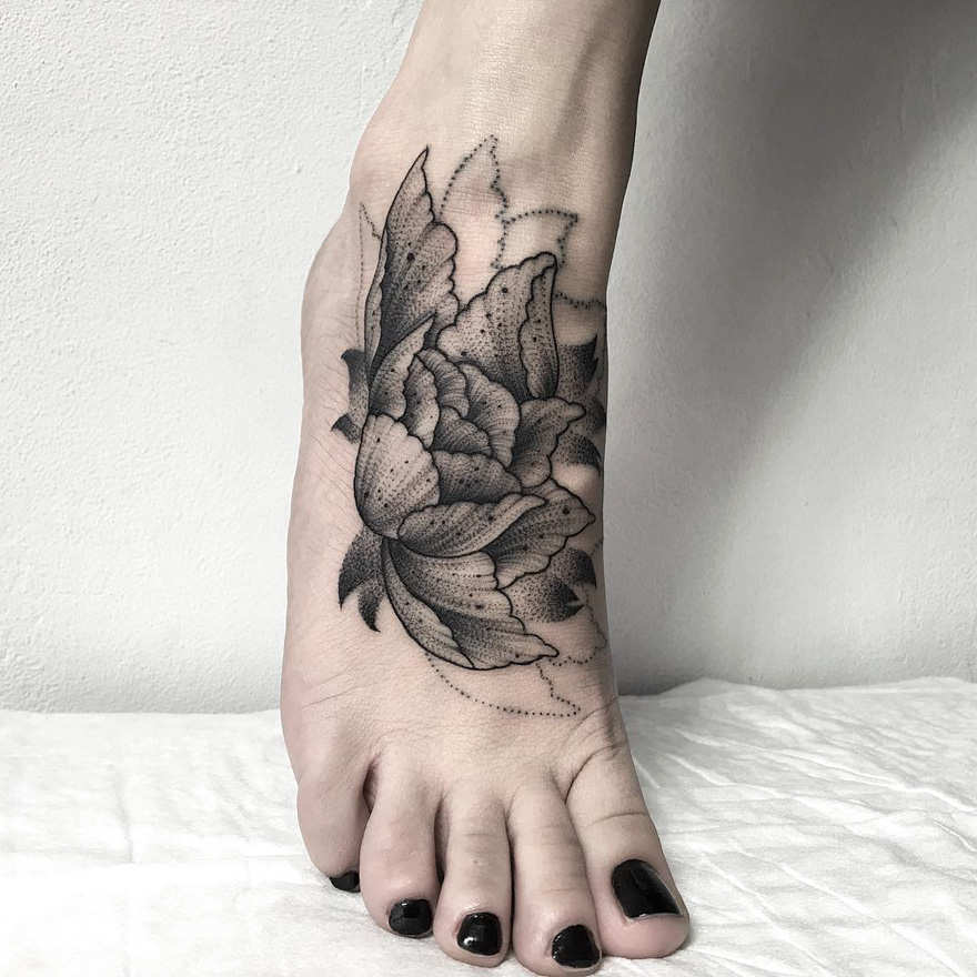 Tattoo of a dark and eerie flower creature on foot by Russian artist.