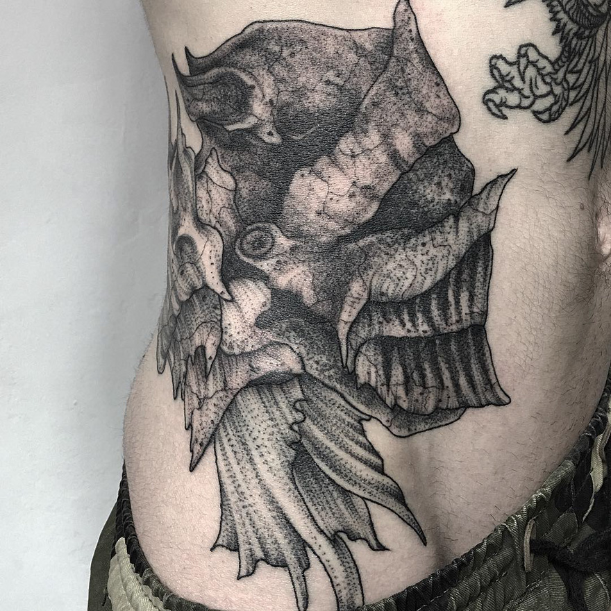 Dark and eerie creature tattoo on skin by Russian artist, showcasing intricate design details and shading.