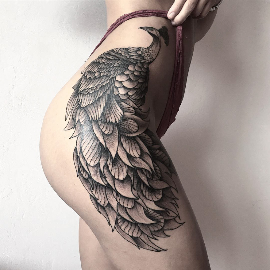 Eerie creature tattoo by Russian artist on a person's hip, featuring intricate feather details.