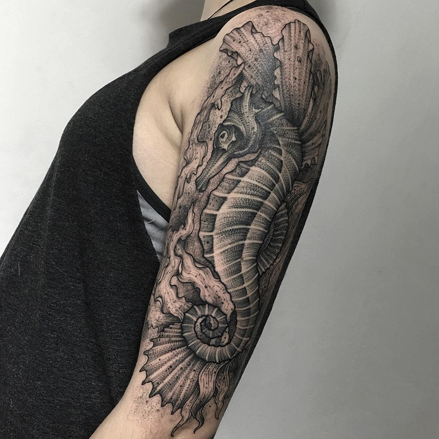Tattoo of a dark and eerie creature by Russian artist, featuring an intricate seahorse design on an upper arm.