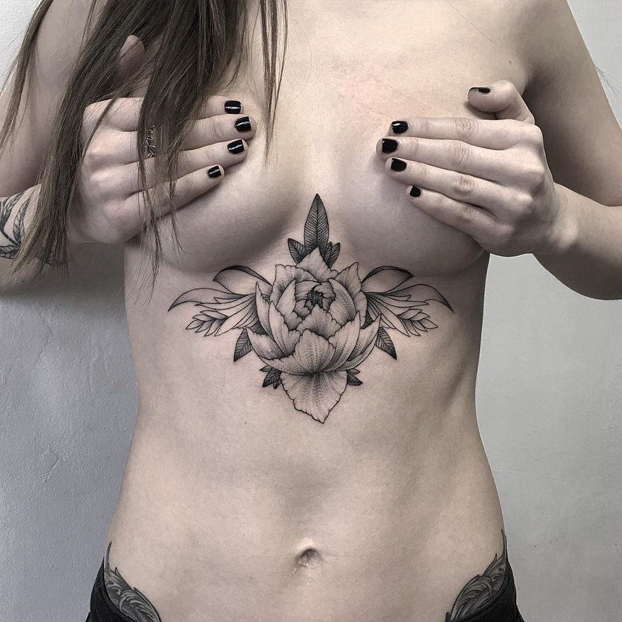 Person with intricate creature tattoo on chest, showcasing Russian artist's dark and eerie tattoo style.