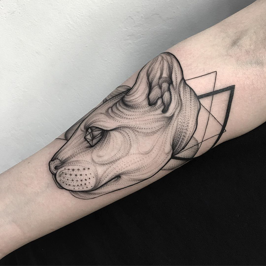 Tattoo of an eerie creature on forearm, designed by a Russian artist.