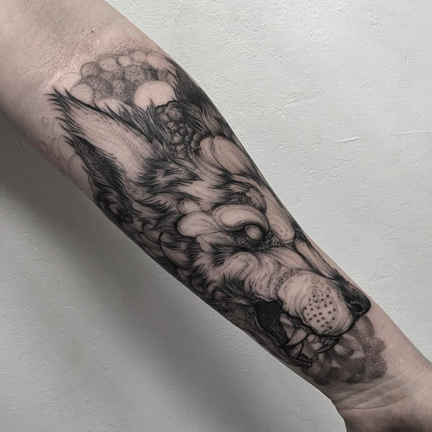 Dark creature tattoo on arm, featuring wolf design by Russian artist.