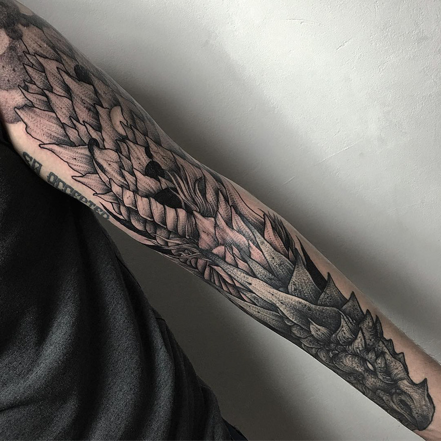 Dark eerie creature tattoo on arm, showcasing intricate design by Russian artist.