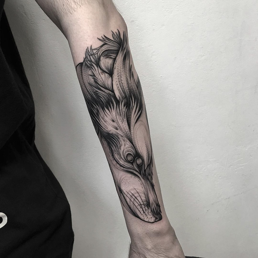 Eerie creature tattoo in black ink on forearm by Russian artist.