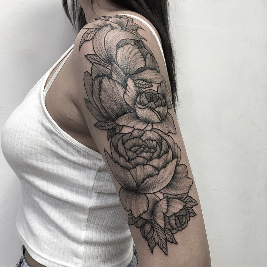 Intricate floral tattoo design on a woman's arm by Russian artist, showcasing detailed artwork.