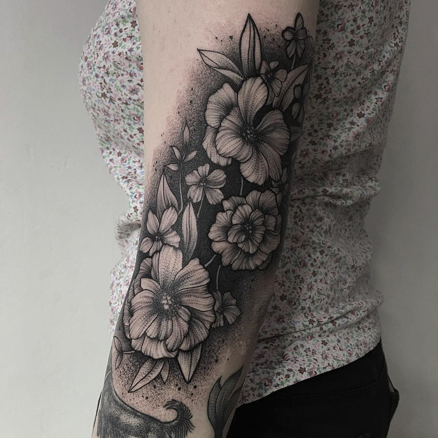 Floral tattoo design on a person's arm, showcasing detailed inkwork by a Russian artist.