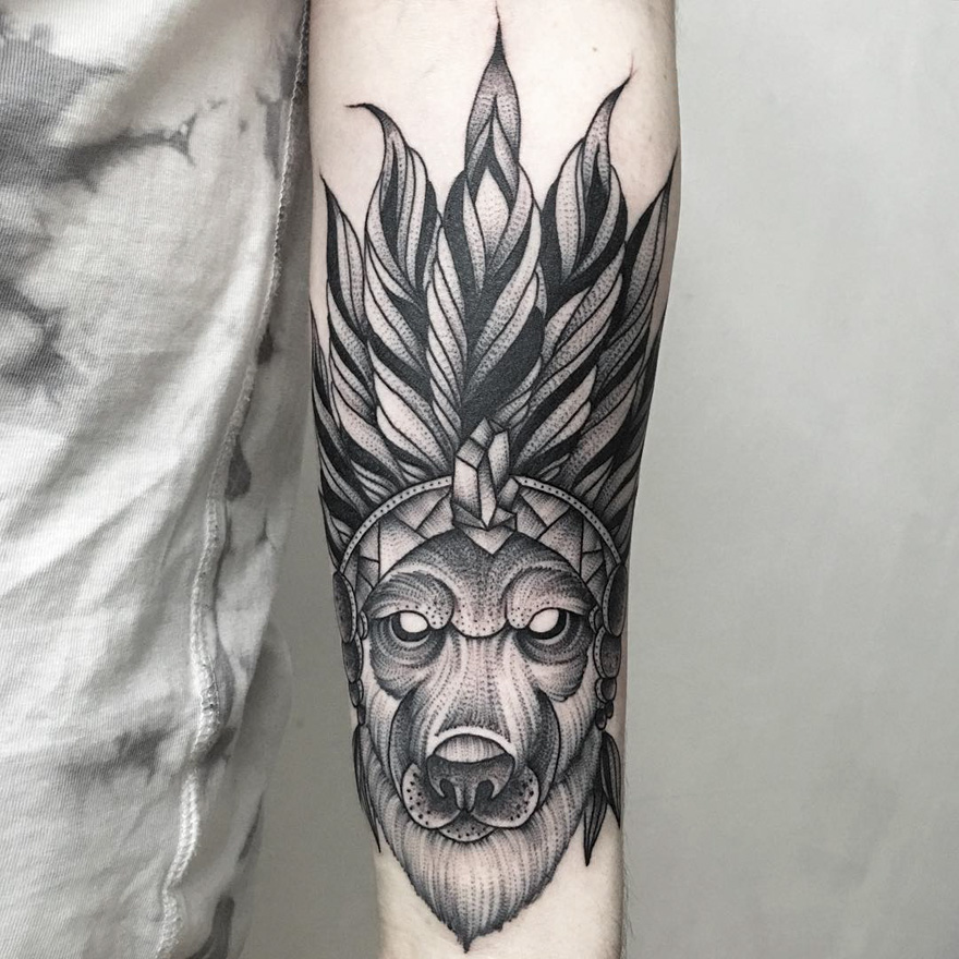 Eerie creature tattoo design by Russian artist on forearm, featuring a wolf with intricate feather detailing.