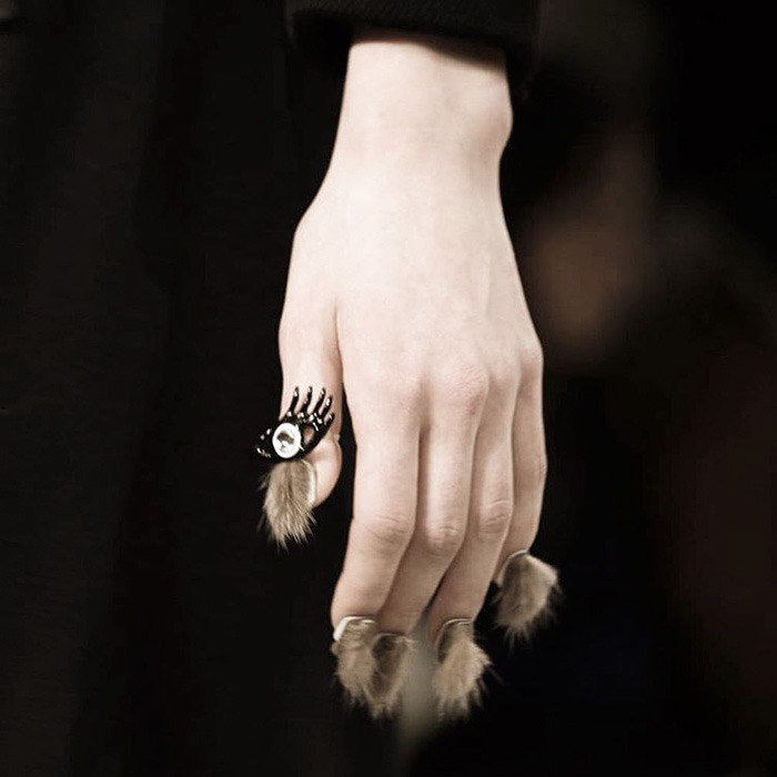 Hand with furry nails featuring hair-like extensions and decorative elements, showcasing the furry nails trend.