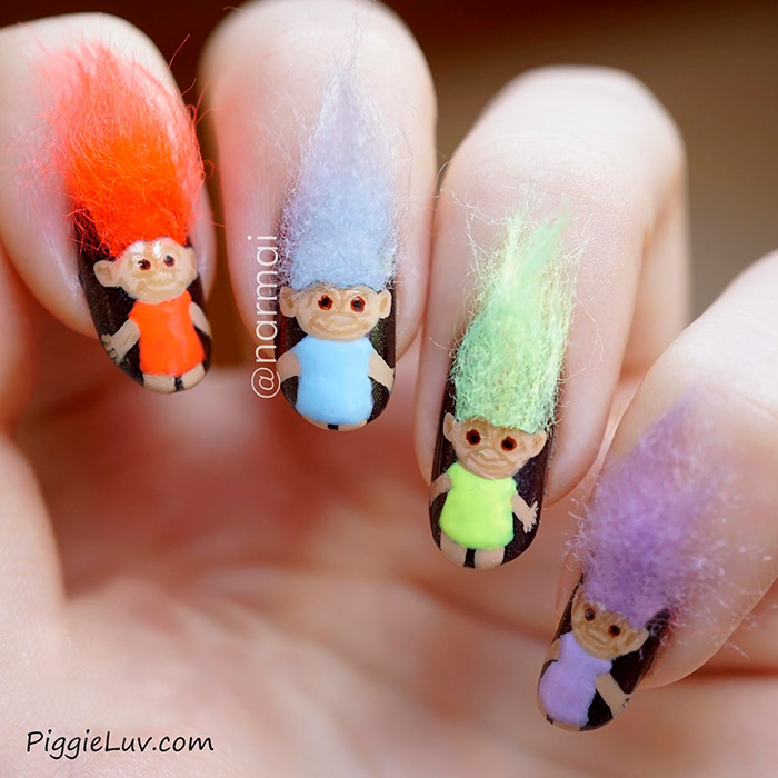 Furry nails featuring colorful troll doll designs with fluffy hair on natural nails, showcasing the hairiest trend in nail art.
