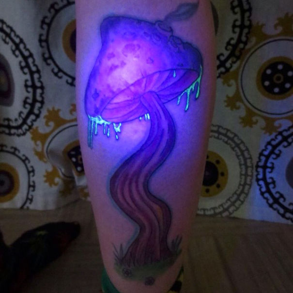 Glow in the dark tattoo of a purple mushroom visible under black light.