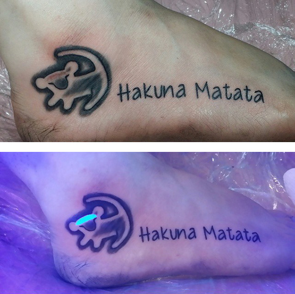 Glow in the dark tattoo of "Hakuna Matata" with lion, visible under black light.
